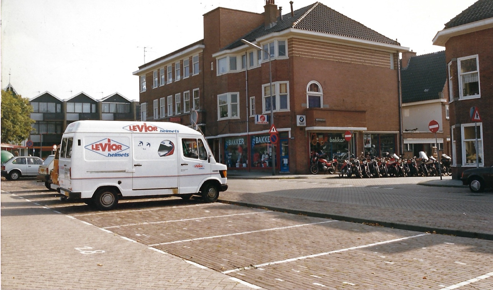 Bakker Motors aan de Burcht in Zaandam, met motoren en de Levior-bus voor de winkel