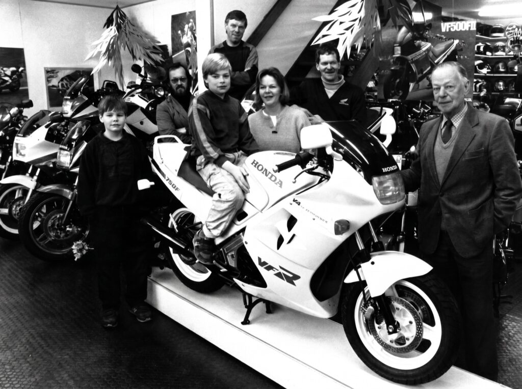 Vier generaties Bakker bij een Honda VFR in de showroom aan de Penningweg