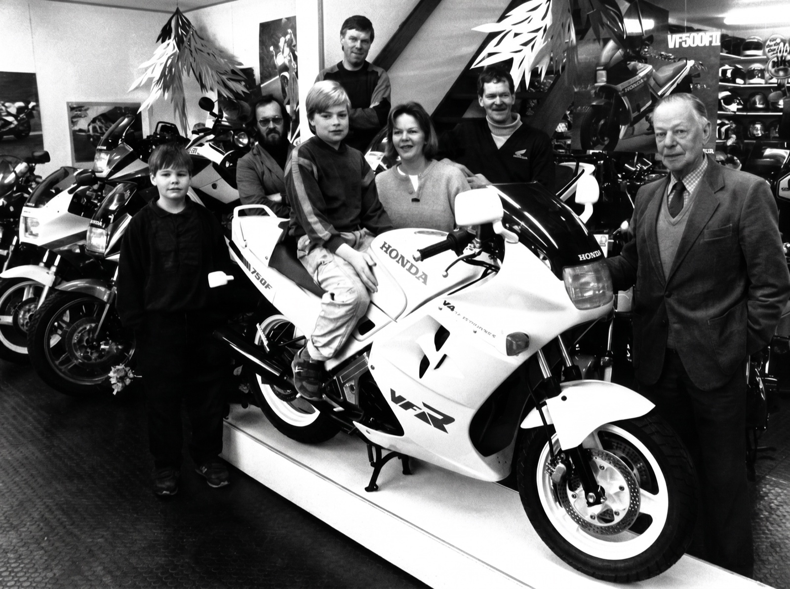 Vier generaties Bakker bij een Honda VFR in de showroom aan de Penningweg