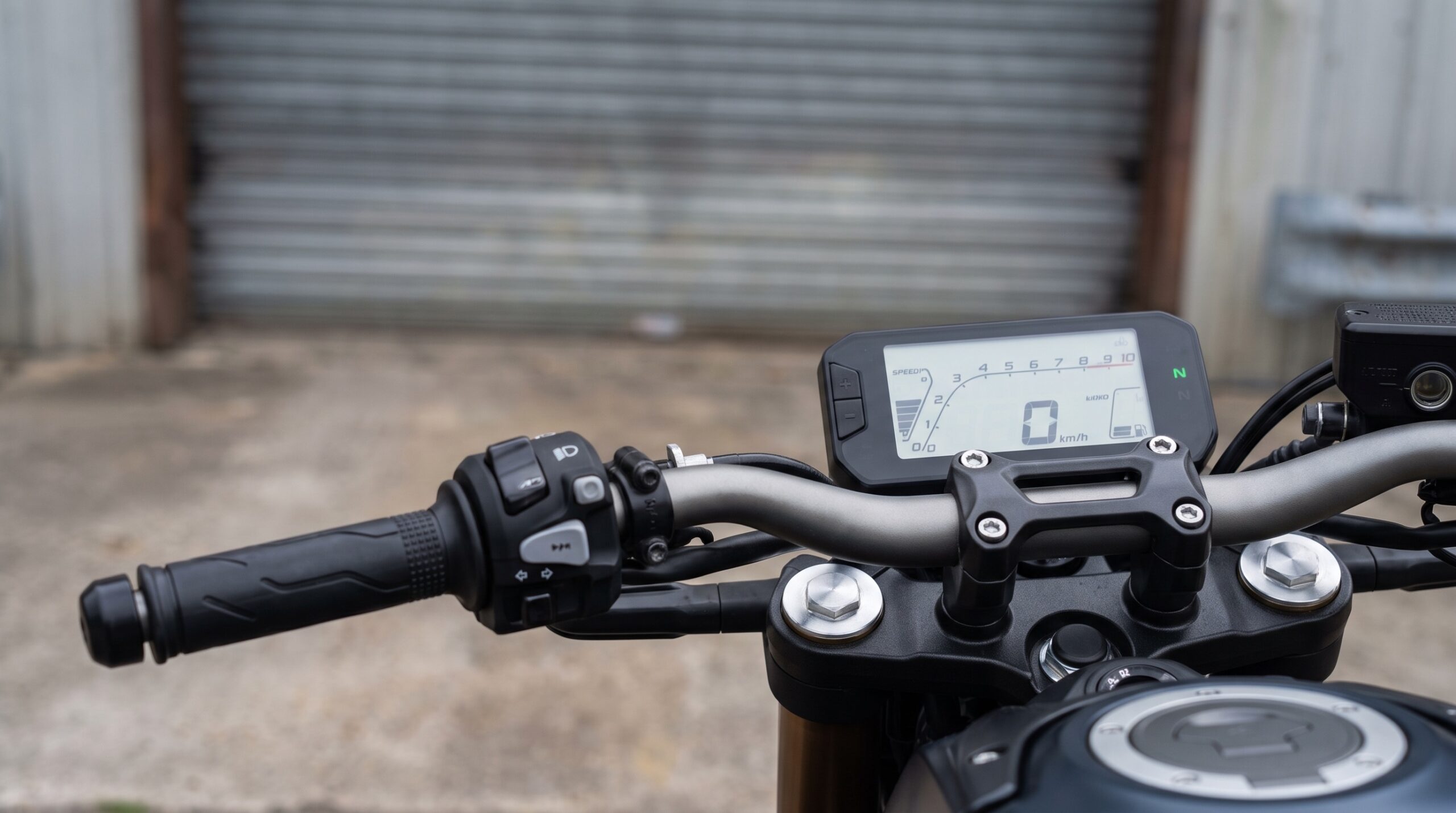 Digitaal motordashboard en linkerstuur zonder koppelingshendel bij een werkplaatsdeur